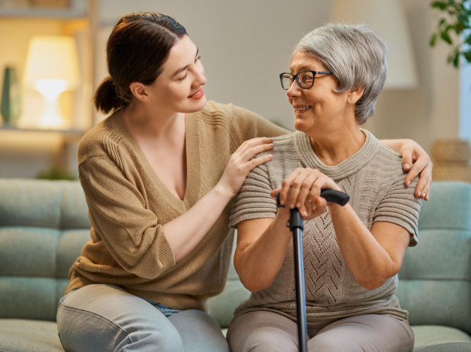 Happy patient and caregiver Happy patient and caregiver spending time together. Senior woman holding cane.
