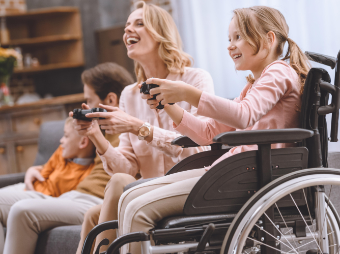 happy family with disabled child in wheelchair playing with joysticks together at home happy family with disabled child in wheelchair playing with joysticks together at home